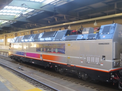 [New York]New Jersey Transit have recently followed in order to run through trains to New York Penn from non electrified routes that join the electric main line. Through bi mode trains run from rhe Midtown Direct, the Rariton  Valley and  Jersey Shore line using new but extremely large  and heavy Bombardier bi-mode locomotives. One is pictured here at Newark Penn station. Formerly these trains had to run Hoboken for the ferry or PATH for New York or terminate at Newark.  Photo by Ian Brown for Railfuture
