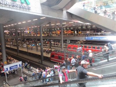 [Berlin]Access to the busy lower level platforms by escalators is shown here. Also shown but you have to look carefully, is the overhead steel bar conductor rail in place of the normal overhead catenary unusual on a main line railway.  Crossrail in London will also use an overhead steel bar. In both cases this is for reliability and to reduce maintenance.  Photo by Ian Brown for Railfuture.