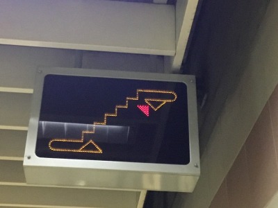 Escalators are spread along Metro platforms but singly to reduce the width of the station box and hence minimise construction costs. These moving signs are clearly visible directing passengers where to go for the escalator, which varies. Photo by Ian Brown for Railfuture
