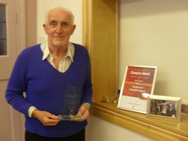 Long-term Railfuture member and volunteers, Paul Jowett, who died in 2019, standing beside a Community Champion 2014 award that he was given